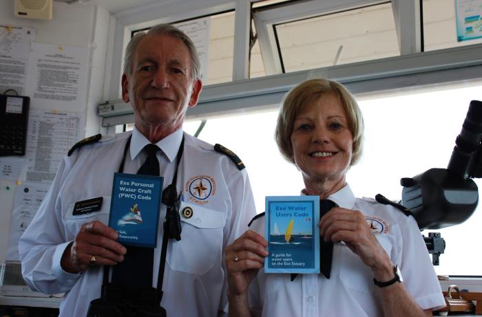 A photo of two Exmouth Coastwatch staff holding Exe Estuary codes of conduct
