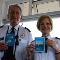 A photo of two Exmouth Coastwatch staff holding Exe Estuary codes of conduct